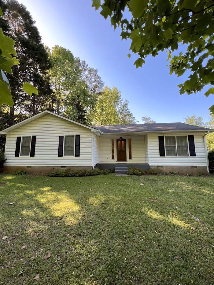 Updated white ranch home with black shutters and tidy lawn in Georgia