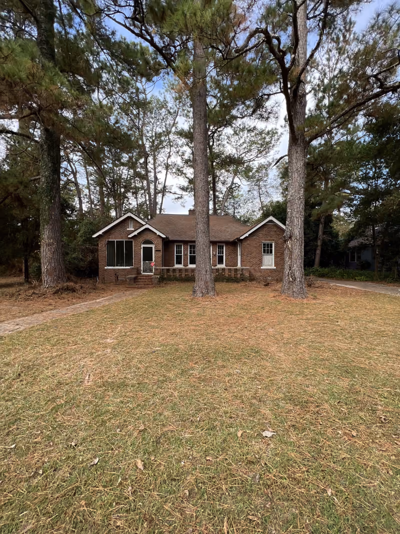 Brick bungalow beneath tall pine trees purchased as-is in Middle Georgia