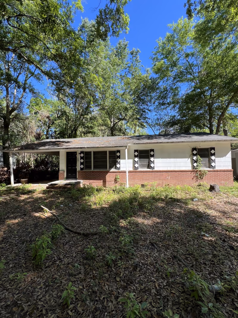 White block house with black diamond shutters and carport, as-is condition, South Georgia